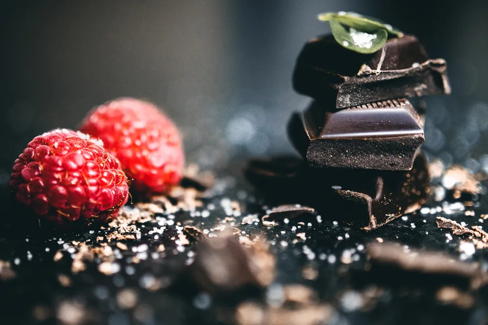 Pieces of dark chocolate with raspberries