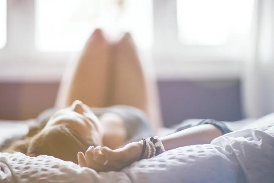 A woman resting comfortably in bed in the morning light